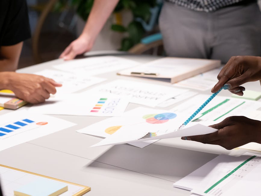Team analyzing documents and charts during a collaborative office meeting.